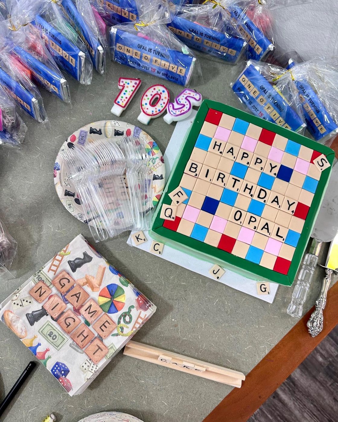 A special-edition Scrabble board spelling Happy Birthday Opal, surrounded by boxed games