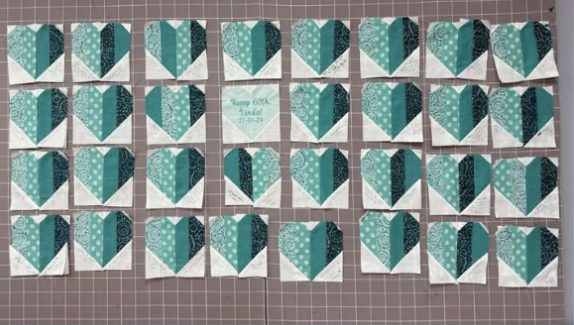 Rows of teal heart quilt blocks signed by party guests